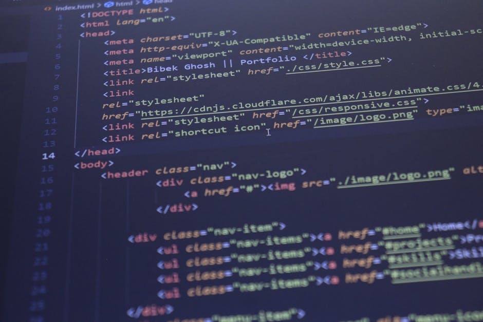 Close-up view of a computer screen displaying lines of colorful source code in a text editor, with syntax highlighting in green, purple, orange, and blue. The background appears blurred, emphasizing t